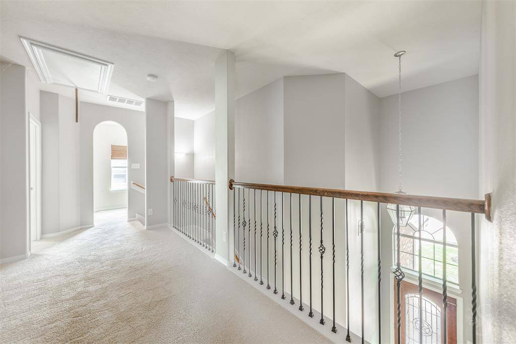 As you stand in the second-floor hallway, a plush carpet extends beneath your feet, offering a soft and inviting texture that enhances the comfort of this upper-level space. The warm, neutral tones of the carpet complement the home's overall aesthetic, creating a cozy and welcoming atmosphere.