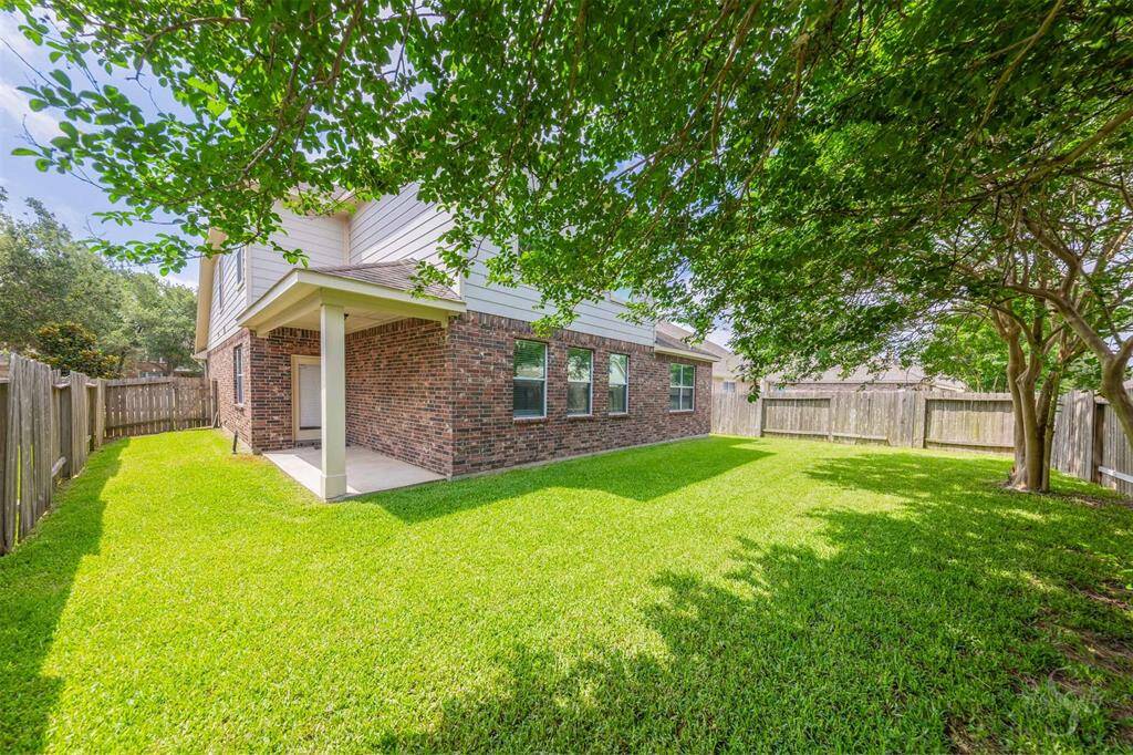 The backyard is a serene outdoor oasis, highlighted by a spacious covered patio that offers both shelter and style. This inviting area is perfect for relaxation and entertainment, providing a comfortable setting for outdoor dining or simply enjoying the fresh air.