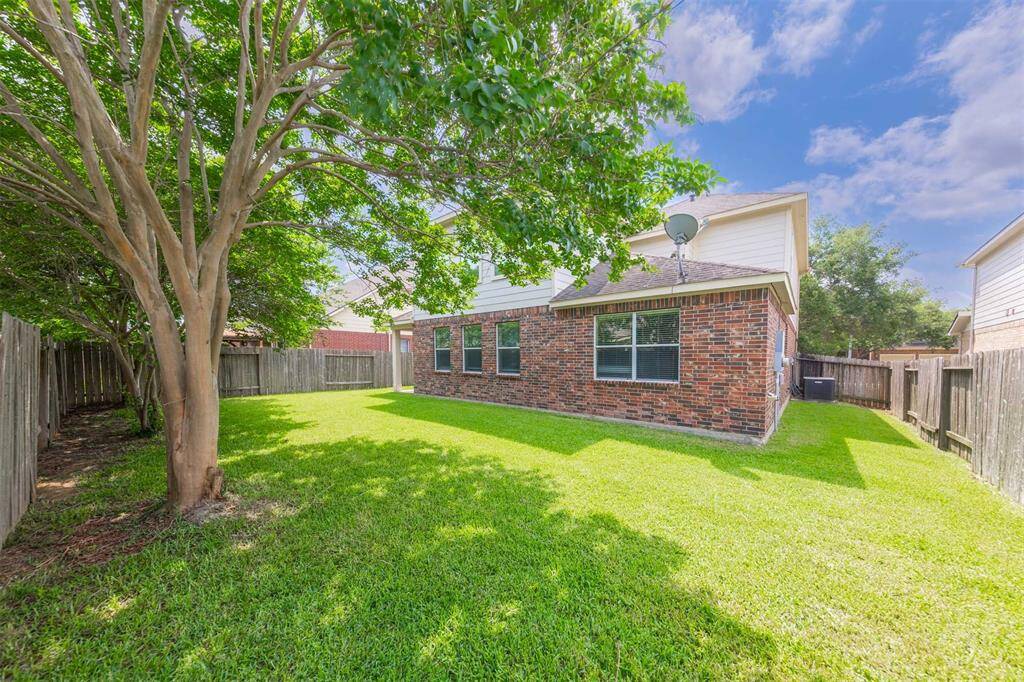 The patio seamlessly transitions into a well-maintained lawn, where lush greenery and thoughtfully placed plants enhance the natural beauty of the space. The expansive yard offers plenty of room for activities, play, or gardening, making it a versatile extension of the home's living area.