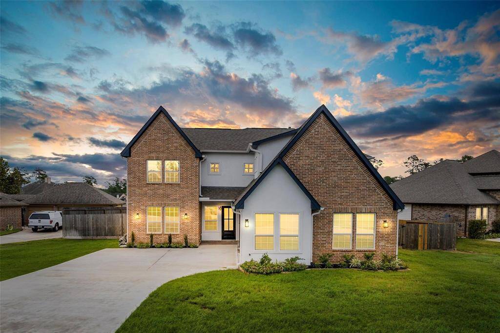 Charming curb appeal with mature trees, a spacious front yard, and a classic brick exterior.