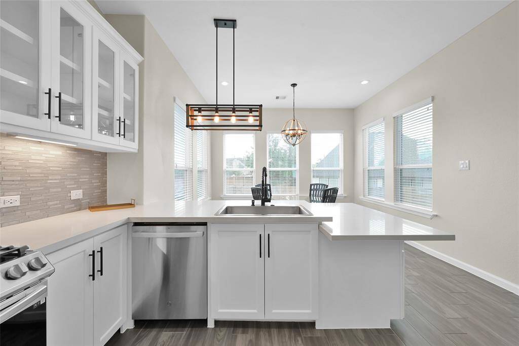 Natural light floods the kitchen and breakfast area, creating a warm and inviting atmosphere.