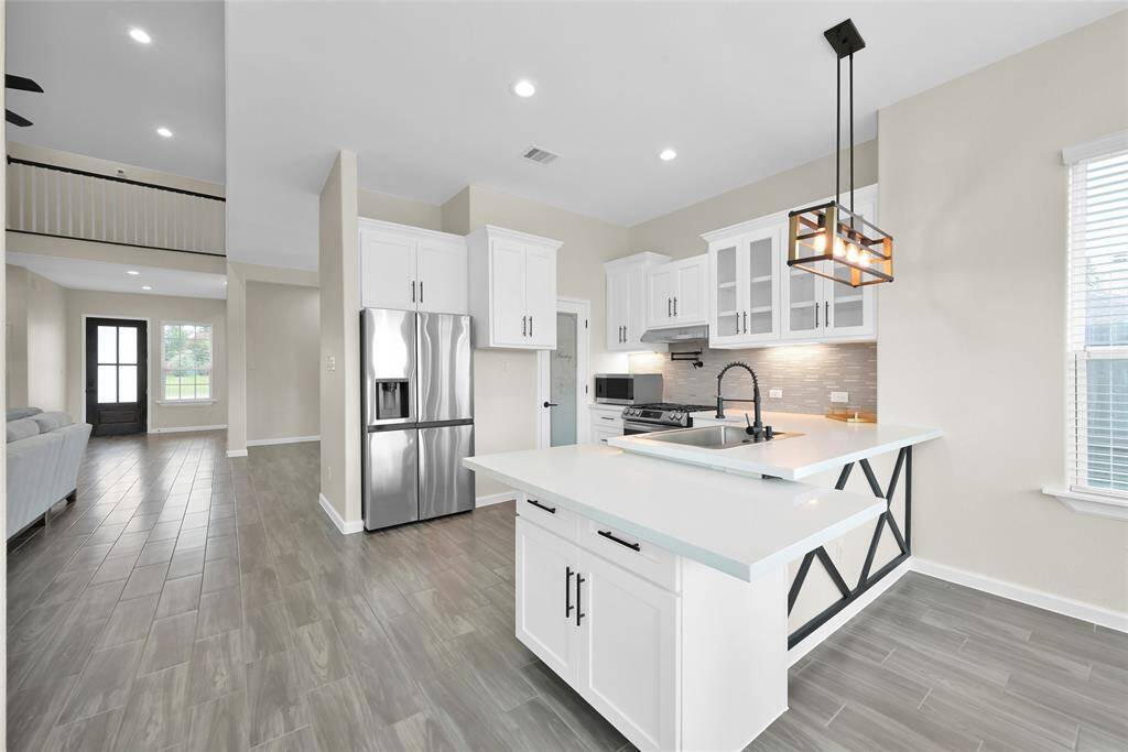 Creative kitchen layout offers distinctive counter space perfect for prep, serving, or display.