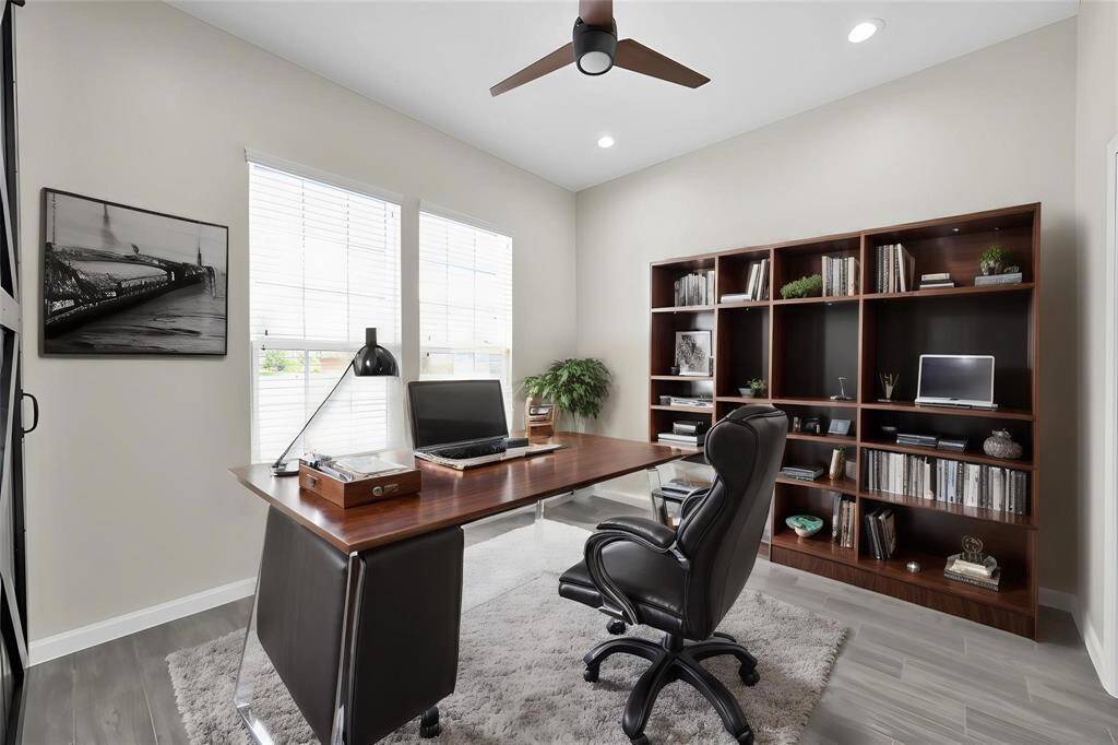 Versatile main-level office features an en-suite full bath, offering the option to serve as an additional bedroom. Disclaimer: This image has been virtually staged to illustrate the property's potential. Furnishings, décor, and enhancements are for visual purposes only and may not reflect actual scale or existing conditions.