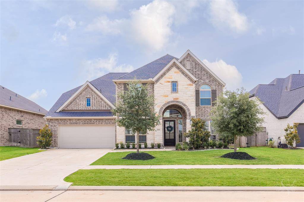 Stunning curb appeal with a mix of brick and stone, this Perry Home exudes timeless elegance and sophisticated design. Manicured landscaping and a stately arched entry welcome you to a home where luxury begins at the front door.