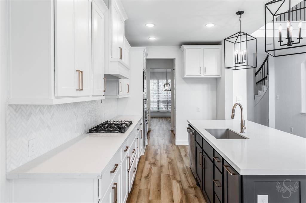 This stunning culinary space showcases custom white cabinetry, Quartz countertops, a gas cooktop with pot filler, and built-in stainless steel appliances. Thoughtful design meets upscale finishes for a kitchen that’s both beautiful and functional.