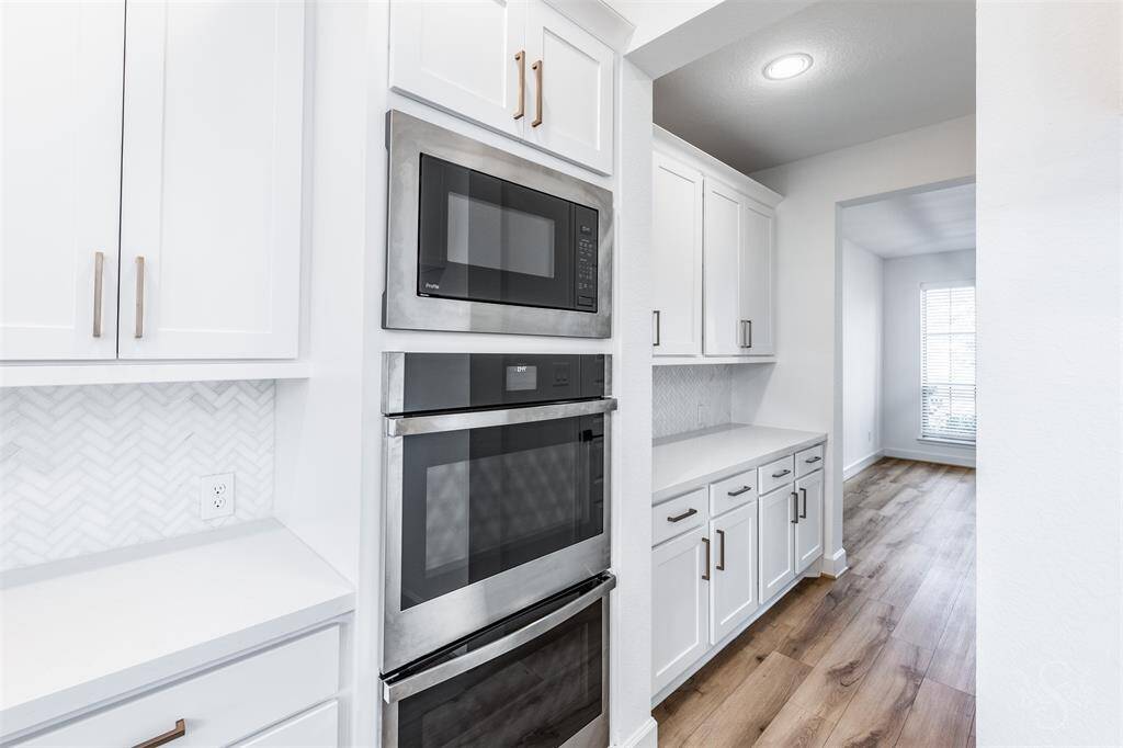 Sleek double ovens and a built-in microwave offer convenience and style, leading into a spacious butler’s pantry for seamless entertaining. The flow from kitchen to dining is ideal for both daily living and hosting in style.