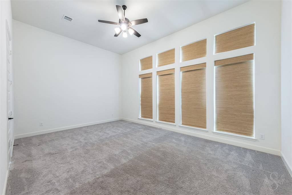 Retreat to the spacious primary bedroom, where soaring ceilings and a wall of picture-frame windows create a peaceful, light-filled haven. The expansive layout easily accommodates a king-sized bed and sitting area for ultimate relaxation.