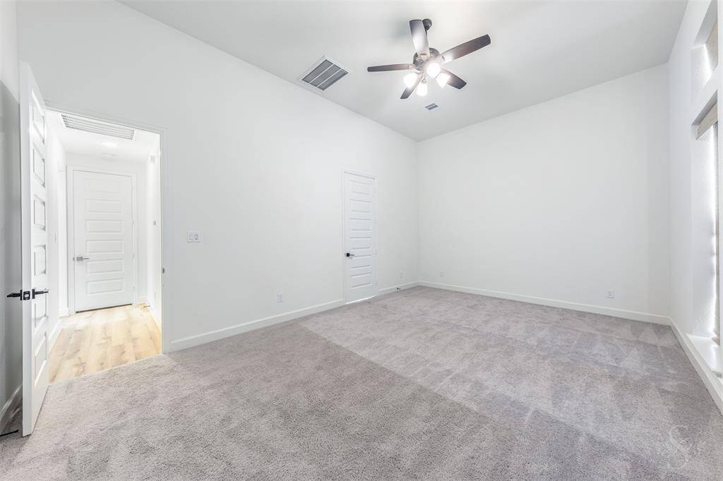 Retreat to the spacious primary bedroom, where soaring ceilings and a wall of picture-frame windows create a peaceful, light-filled haven. The expansive layout easily accommodates a king-sized bed and sitting area for ultimate relaxation.