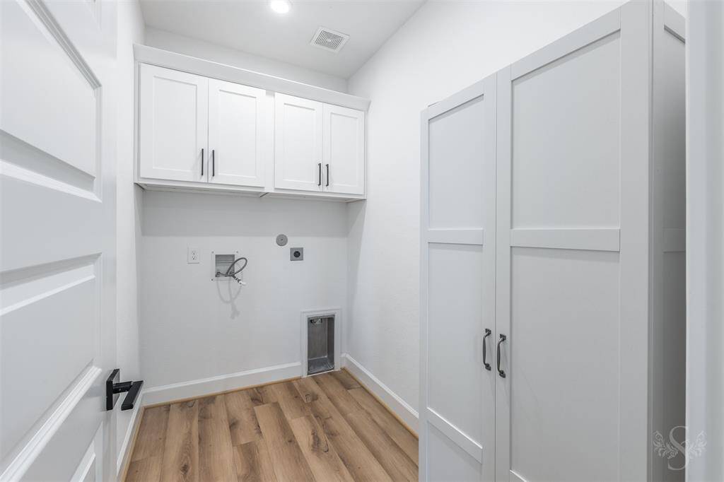 The spacious laundry room is both stylish and functional, with upper cabinets for storage, storage cabinet and durable flooring. Thoughtful design details add convenience to daily routines.