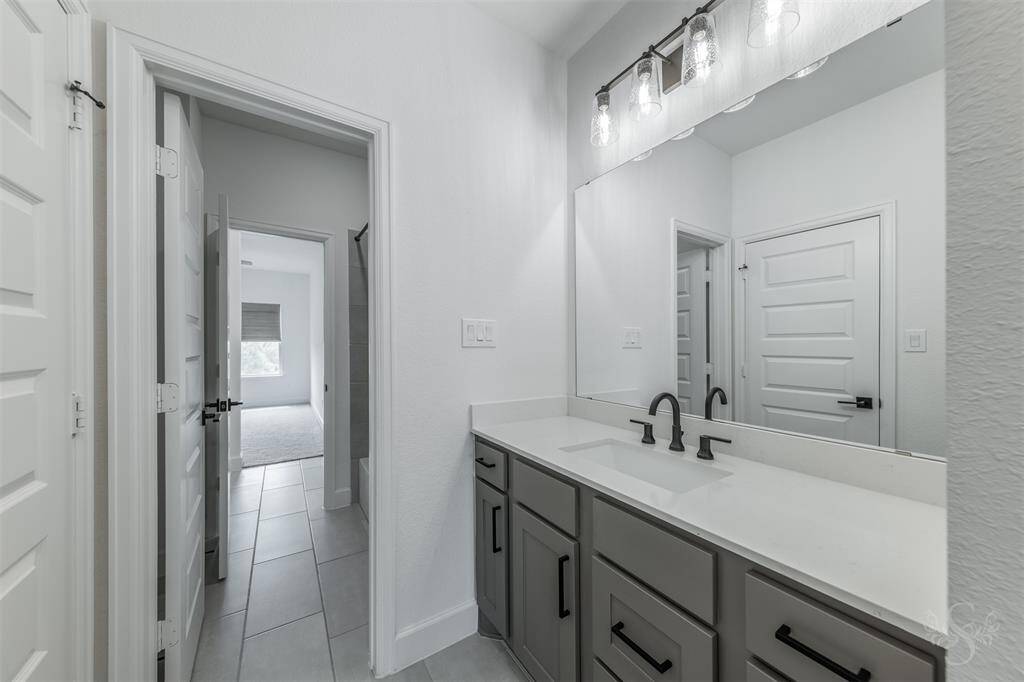 This shared full bath features an extended quartz countertop and is ideal for busy mornings with easy access to the tub/shower combo from both bedrooms.