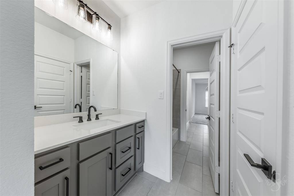 This shared full bath features an extended quartz countertop and is ideal for busy mornings with easy access to the tub/shower combo from both bedrooms.