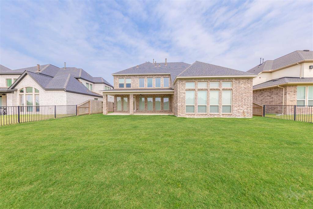 Showcasing the home’s striking rear façade, the spacious patio and lush yard invite vibrant outdoor entertaining and peaceful evenings alike. A perfect setting to unwind or gather in style.