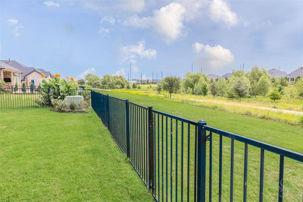 Enjoy uninterrupted views of the greenbelt from your backyard, where the iron fence preserves your connection to nature. The trail just beyond invites morning strolls and sunset walks.