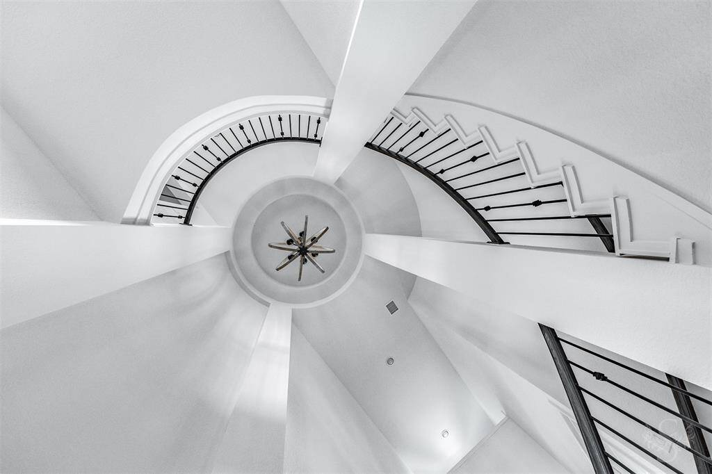 An artful display of symmetry and design, the spiral staircase wraps gracefully beneath the rotunda, drawing your eye upward to the luxurious chandelier centerpiece. A true statement of grandeur and craftsmanship.