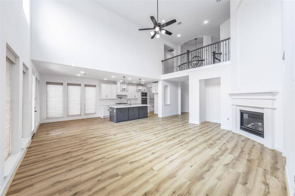 This breathtaking open-concept space seamlessly connects the two-story family room to a gourmet kitchen with designer lighting and a bold color island. Whether hosting or relaxing, this heart-of-the-home layout delivers style and comfort.