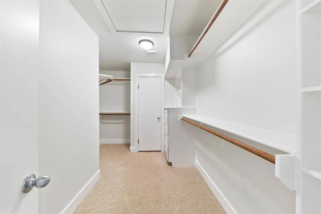 Spacious walk-in closet with ample shelving and hanging space, designed to keep your wardrobe organized and accessible.