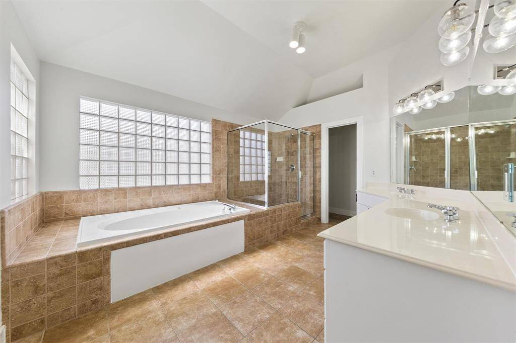 Spacious primary bathroom featuring a separate shower and tub, designed for both comfort and convenience