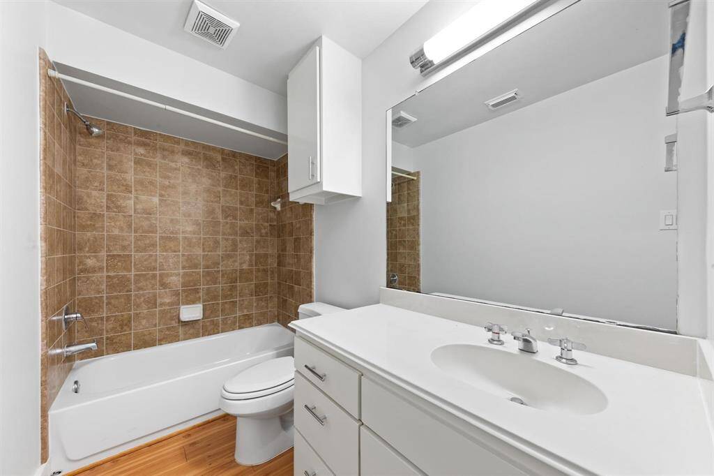 First-floor full bath with modern fixtures, sleek vanity, and a tiled tub/shower combo—conveniently located for guest use or adjacent bedroom access