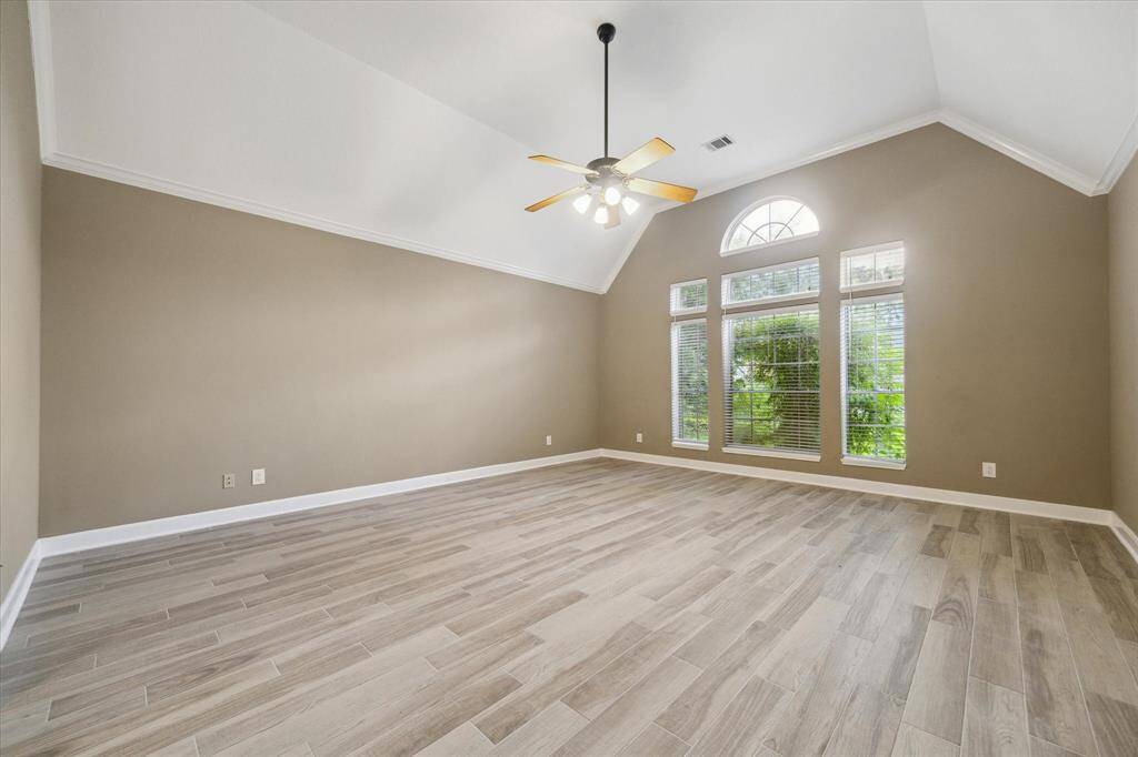 Welcome to the palatial primary suite—a true retreat featuring generous space, serene ambiance, and elegant finishes for ultimate comfort.This spacious room features high vaulted ceilings, a ceiling fan, and large windows that provide plenty of natural light.