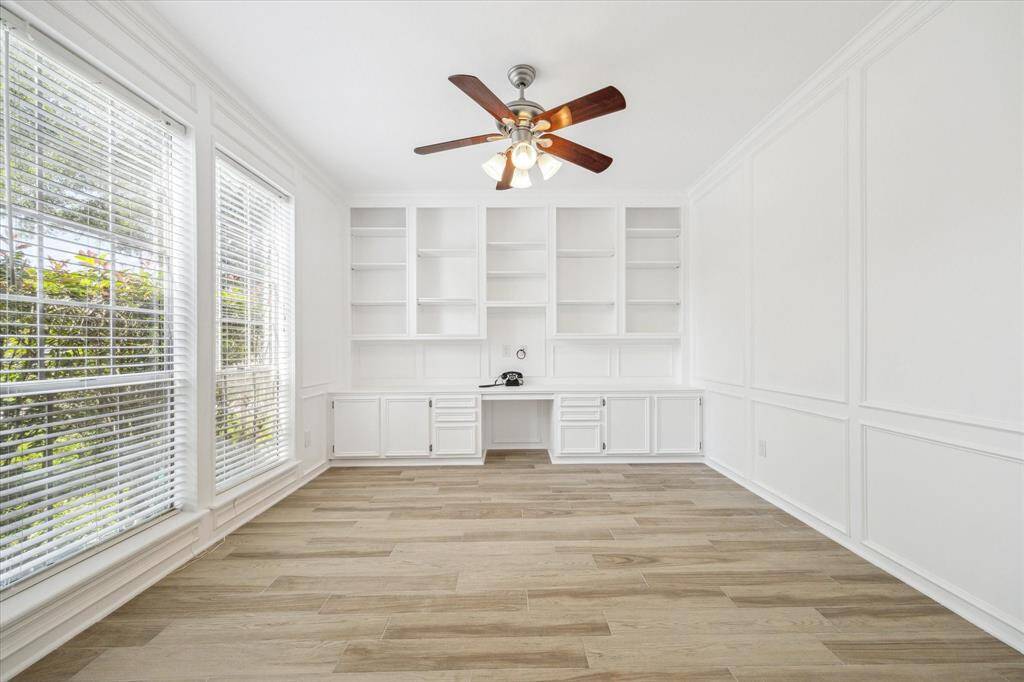 The perfect workspace features a convenient built-in desk and custom shelving, offering both functionality and style for your home office needs.