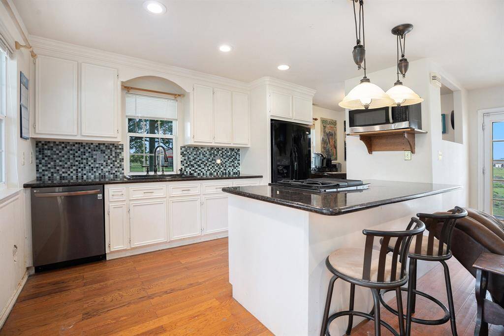 Kitchen has great cabinet space, granite countertops, decorative backsplash, and dishwasher. The gas stove is placed in the island for views while you cook.