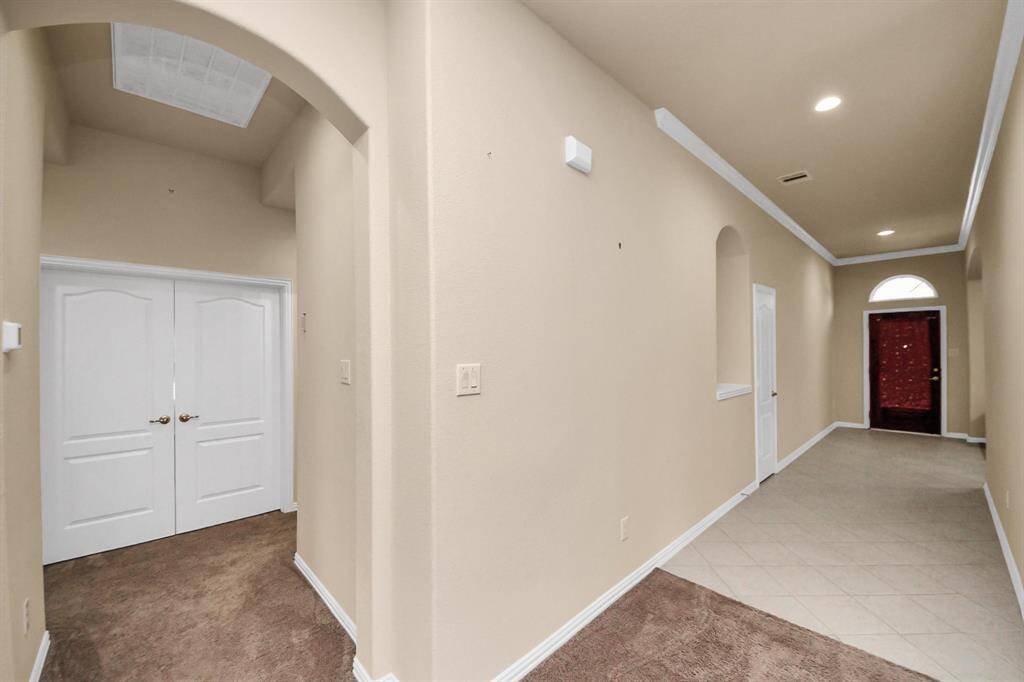It features recessed lighting, neutral walls, and arched doorways, providing a welcoming and elegant entryway.?