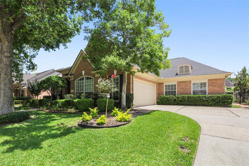 This charming brick home features a well-maintained front yard with lush landscaping, a spacious driveway, and a two-car garage swing in. The large windows and inviting exterior create a welcoming atmosphere in a serene neighborhood setting.