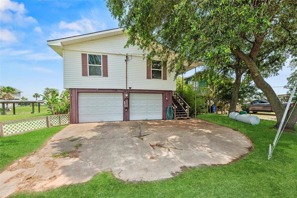 Spacious double concrete driveway leading to a two-car garage, with plenty of room for parking or storage.