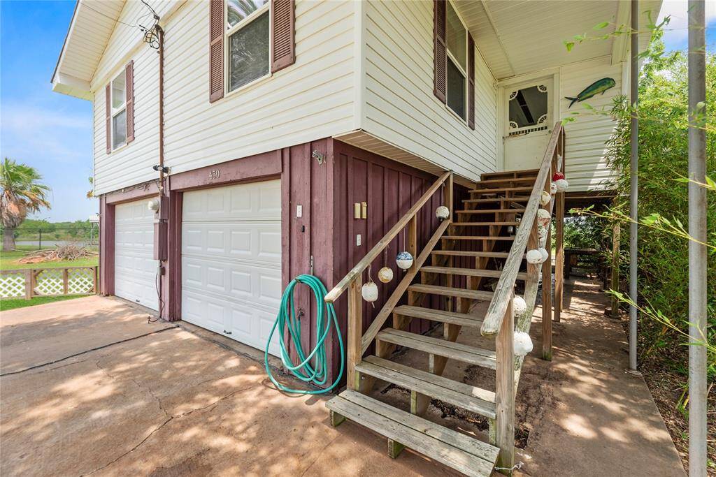 Wooden staircase with nautical-themed railing leads to a cozy covered front entry, perfect for enjoying Gulf breezes.