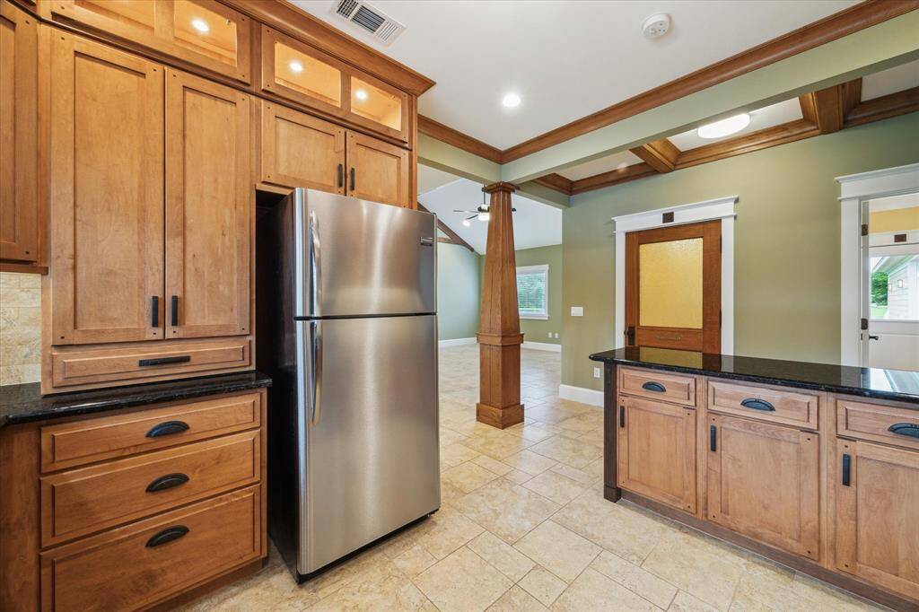 THE KITCHEN IS WRAPPED IN CUSTOM CABINETS THOUGHTFULLY DESIGNED TO OFFER AN ABUNDANT STORAGE WITH SPECIALIZED COMPARTMENTS FOR POTS, PANS, AND DISHES OF ALL SHAPES AND SIZES.