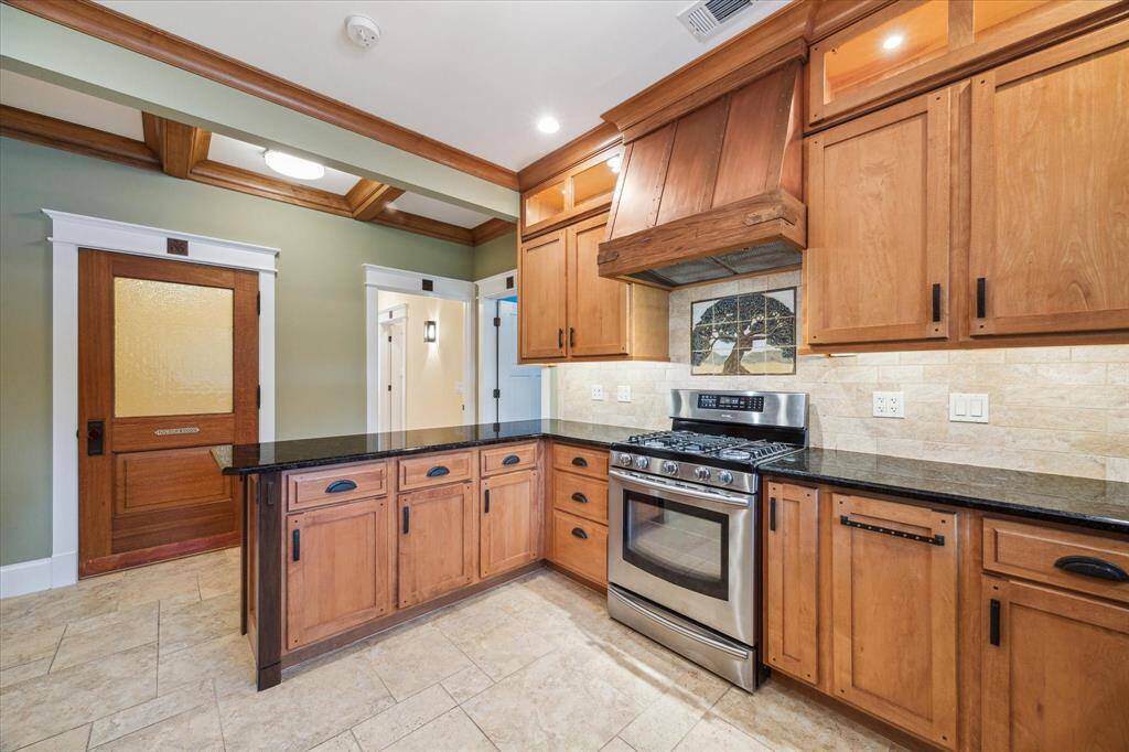 THIS VIEW OFFERS A LOOK TOWARDS THE STUNNING POWDER ROOM WITH CUSTOM WOOD DOOR MOLDING AND WOOD DETAILED CEILING ABOVE IN THE HALLWAY