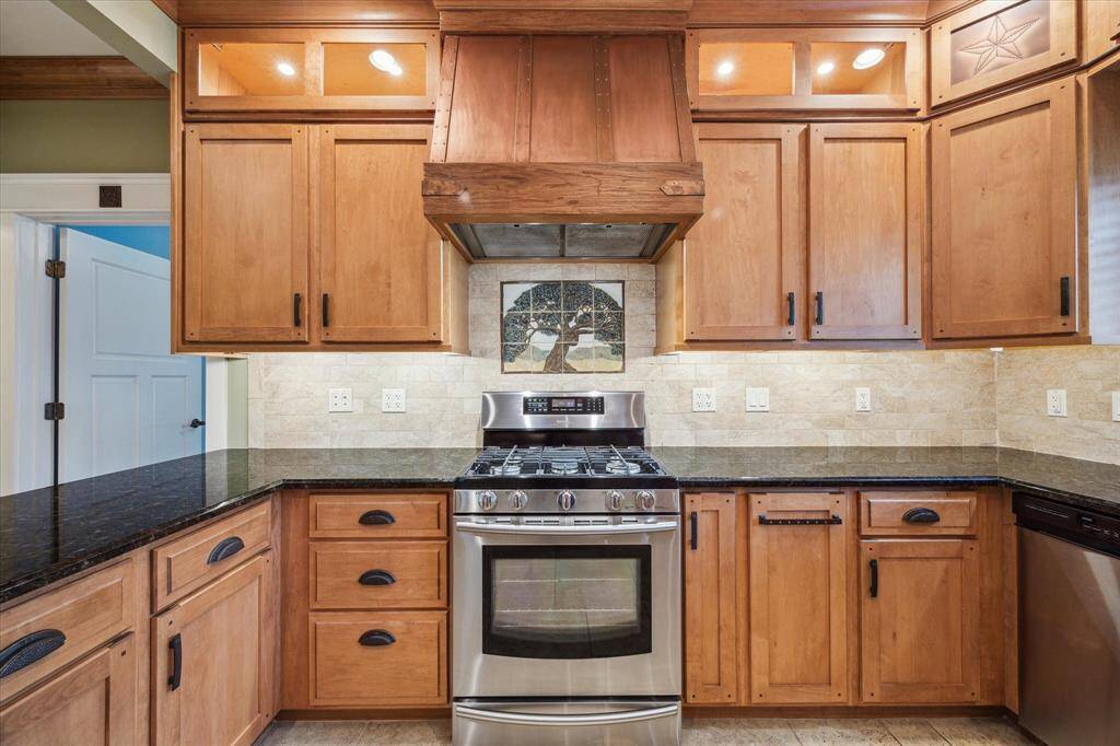 THE SPACIOUS KITCHEN IN THE HEART OF THE HOME SURROUNDED BY CUSTOM WOOD CABINETRY AND EXCEPTIONAL BEAUTY.
