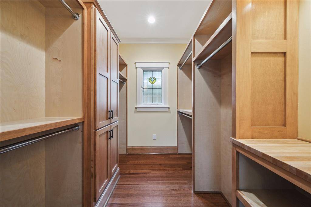 THE PRIMARY SUITE FEATURES A CUSTOM WALK-IN CLOSET DESIGNED FOR ULTIMATE ORGANIZATION OUTFITTED WITH BUILT-IN CABINETS, AMPLE SHELVING AND MULTIPLE HANGING RODS.