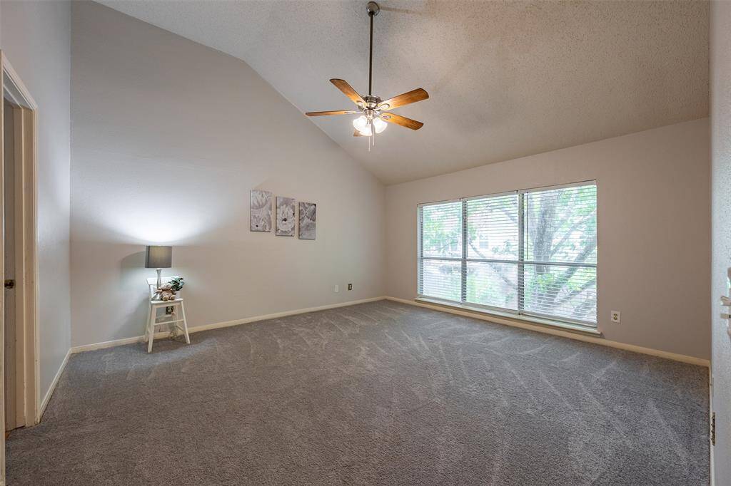 The spacious primary suite offers vaulted ceilings, plush carpet, and extra large windows offering lots of views and natural light.