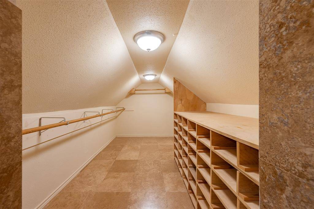 Large custom closet with built-in storage and spacious vanity area with mirror wall.