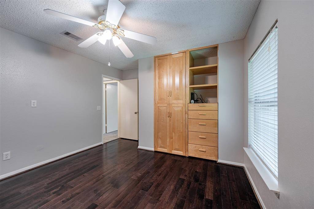 Spacious bedroom with custom closet and ceiling fan for added comfort.