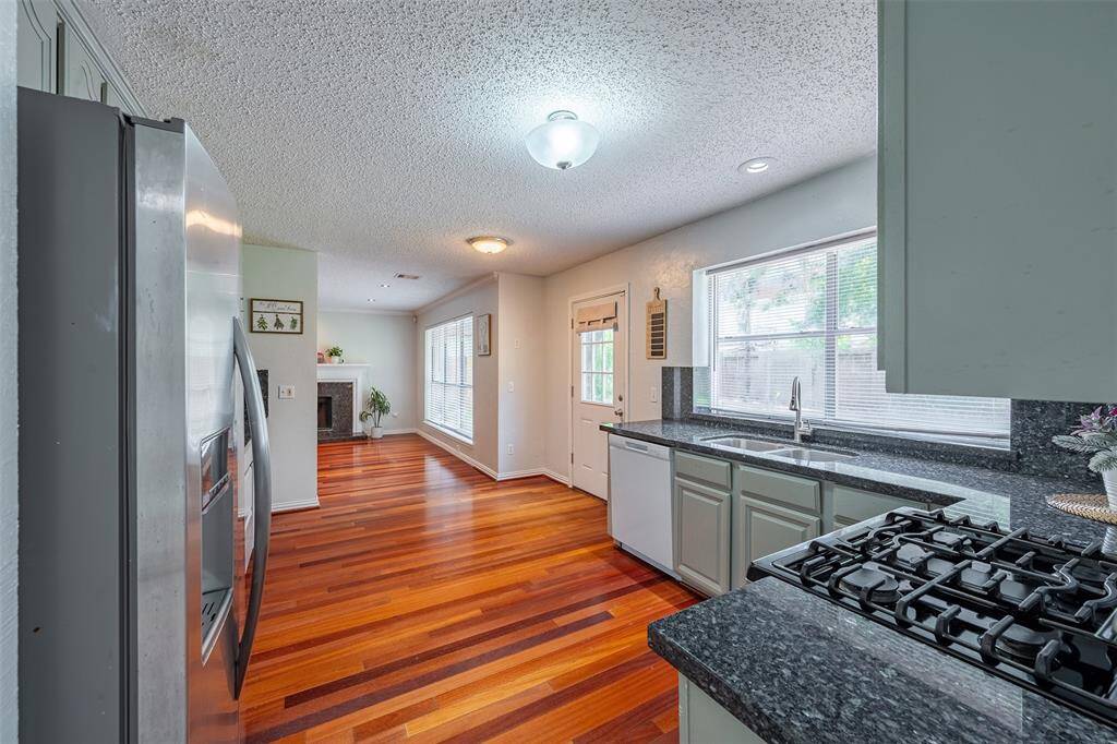 Spacious kitchen boasts granite counters, ample cabinet space, stainless steel appliances, and brand-new (2025) dishwasher and garbage disposal.