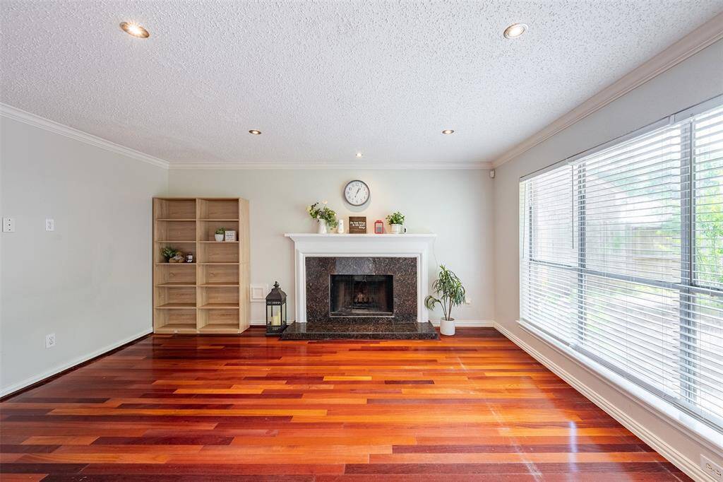 Full of natural light, the family room features a cozy gas fireplace framed by a modern black facade and white mantel.