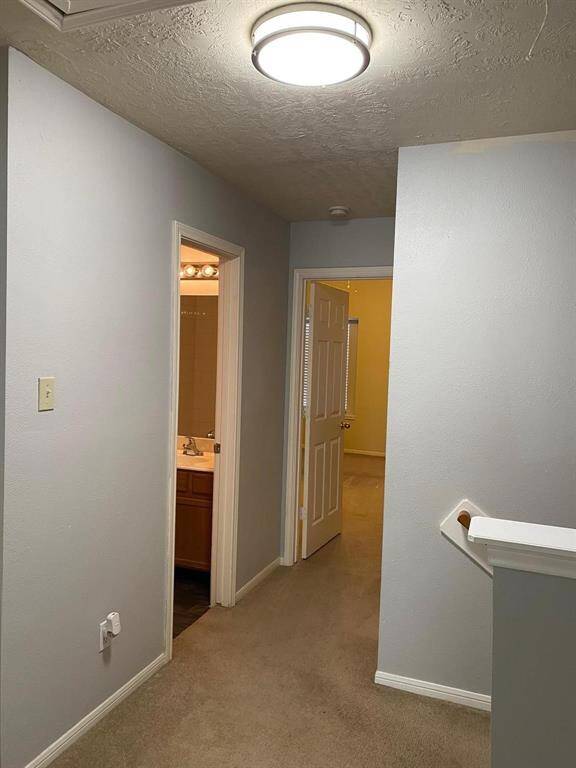 This bathroom features a classic design with a bathtub-shower combo, a single-sink vanity with storage, and a large mirror. The walls are painted in a vibrant teal, complemented by bright overhead lighting.