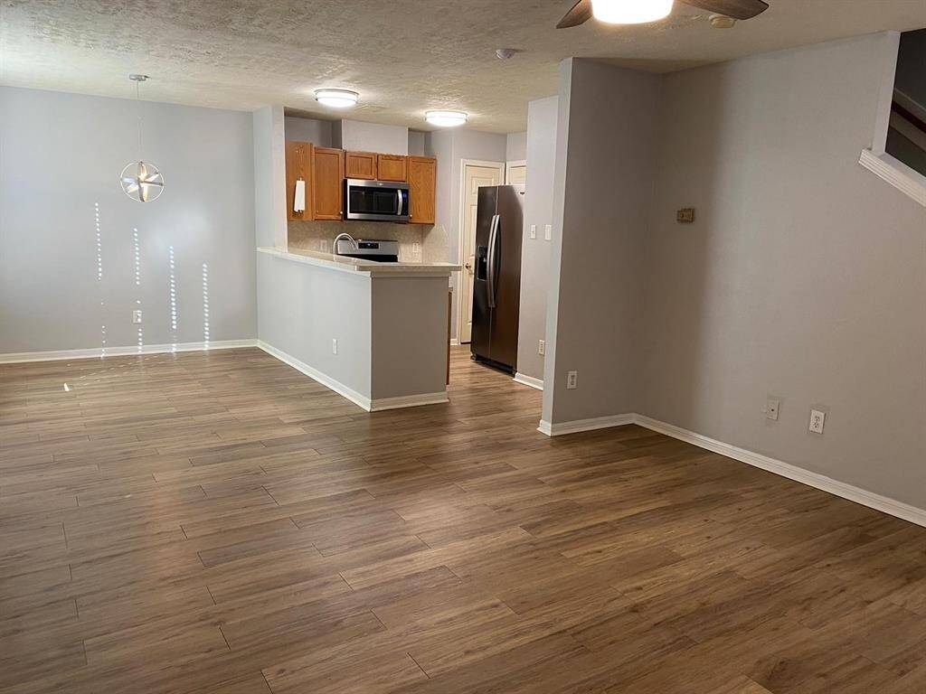 This is a cozy entryway featuring a light gray door and walls, with wood-look flooring and a modern ceiling light fixture.