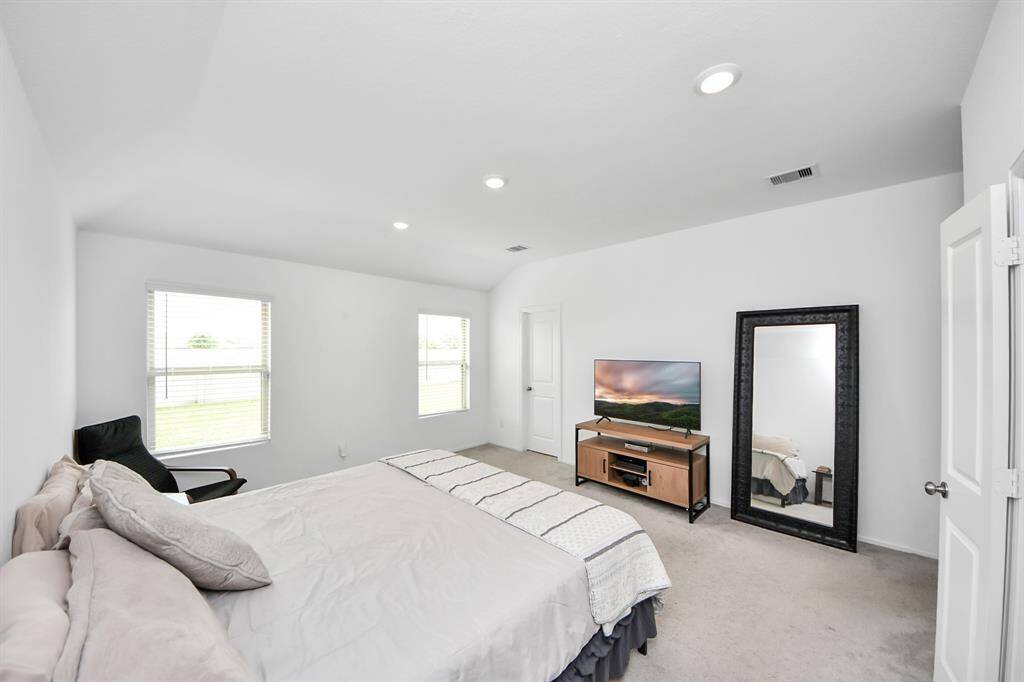 Spacious primary bedroom with pass through closet to laundry room.