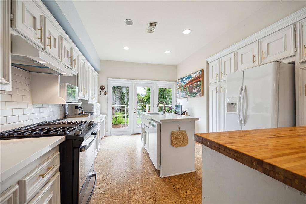 This bright and spacious kitchen has abundant cabinetry and beautiful views to the backyard.