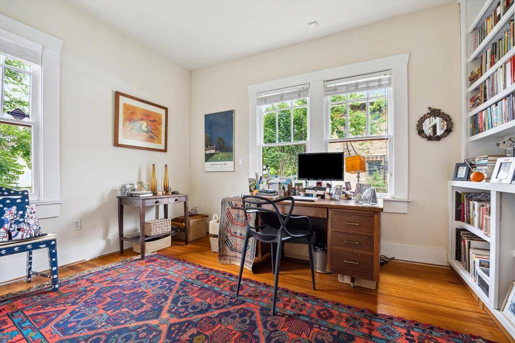 Second bedroom is filled with natural light and features built-in bookshelves, a walk-in closet and windows overlooking the back and side yards.