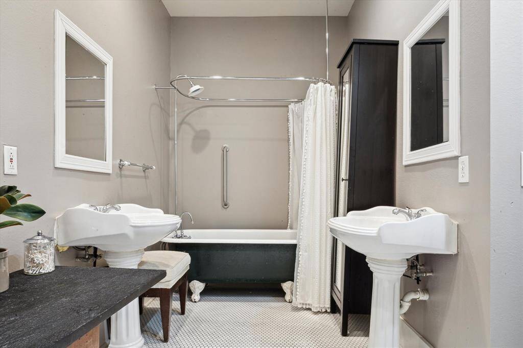 This beautifully updated bathroom is shared by the two secondary bedrooms and features classic hex tile, dual pedestal sinks and a vintage clawfoot tub.
