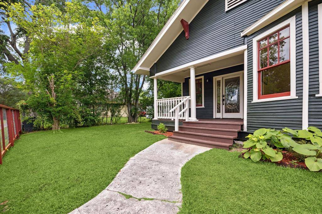 A curved path leads though the lush front lawn to a wide welcoming porch.