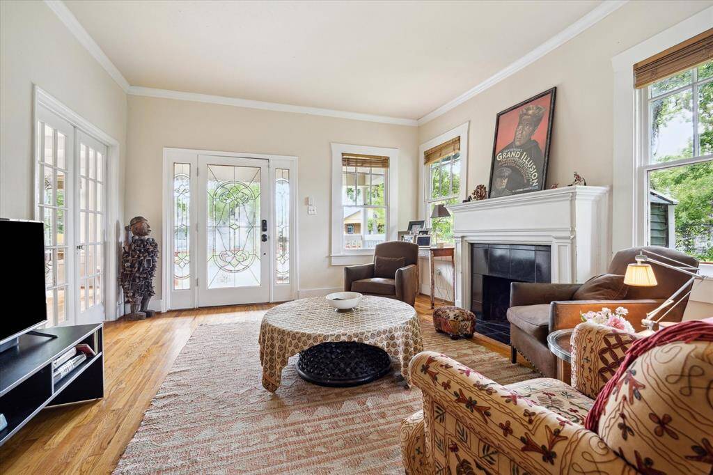 Filled with natural light, the living room offers a warm welcome with its classic fireplace. The double doors to the left lead to the first bedroom.