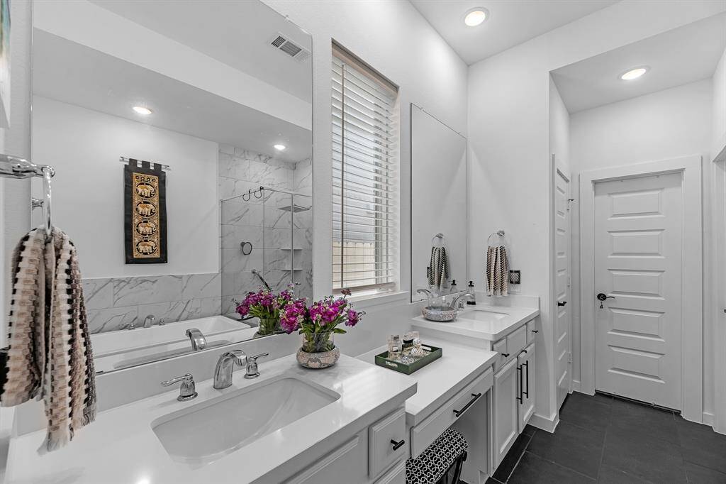 Primary bath with his and hers sinks and a separate vanity area.