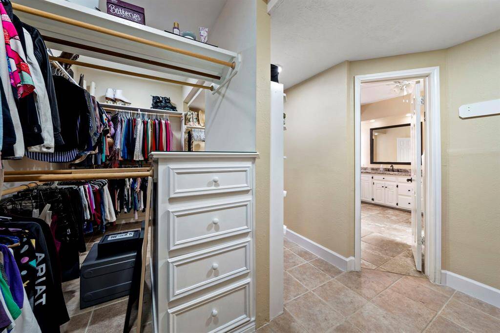 Another view of the Primary closet. Very spacious with shelves and drawers on both sides. This is a dream closet.