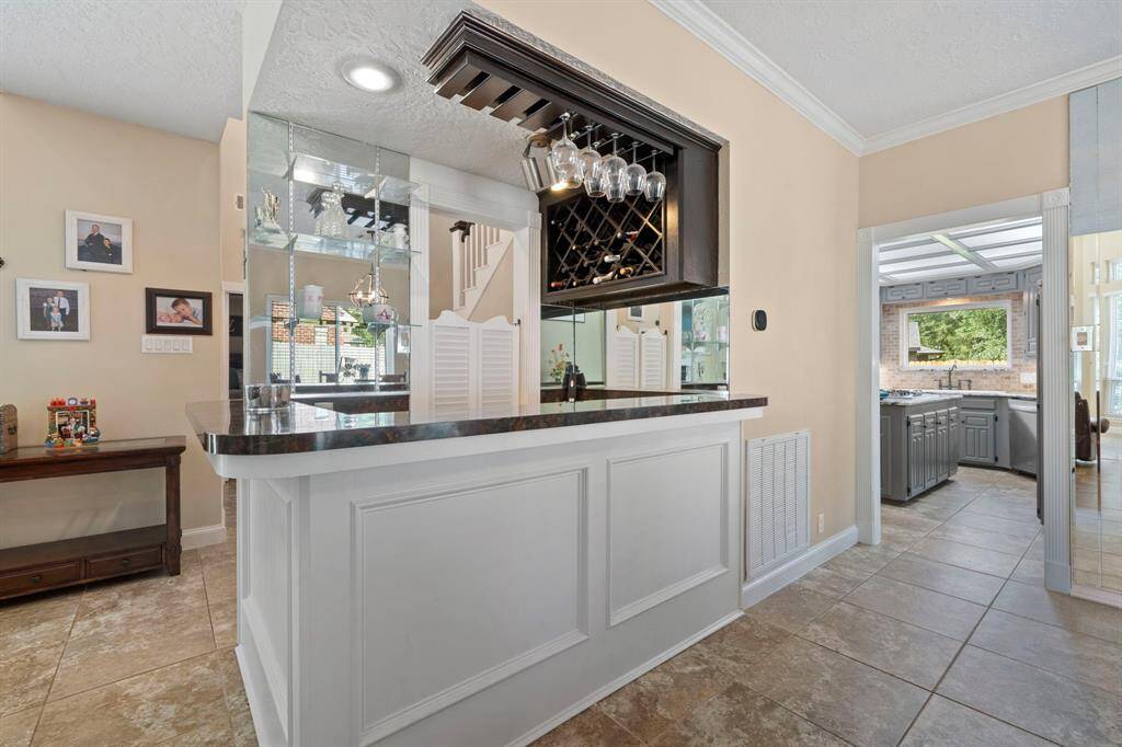This bar is centrally located with built-in wine glass rack, open to living area and dining room and ready for entertaining.