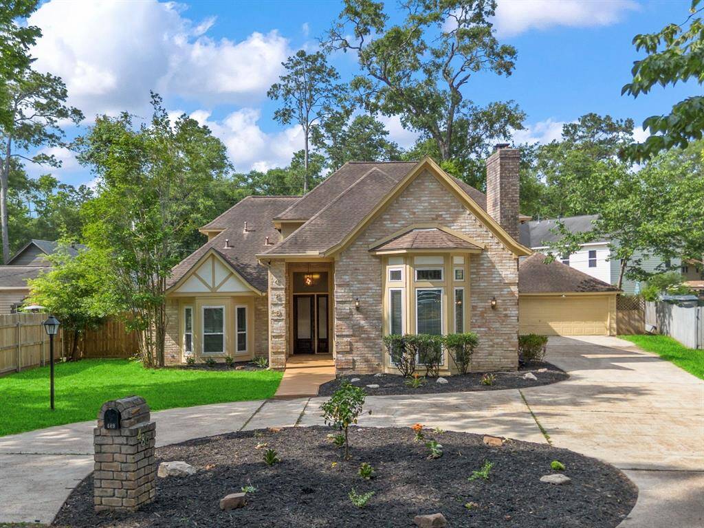 Another view of the inviting front entry with circular driveway. Surrounded by mature trees, offering privacy and a natural setting.
